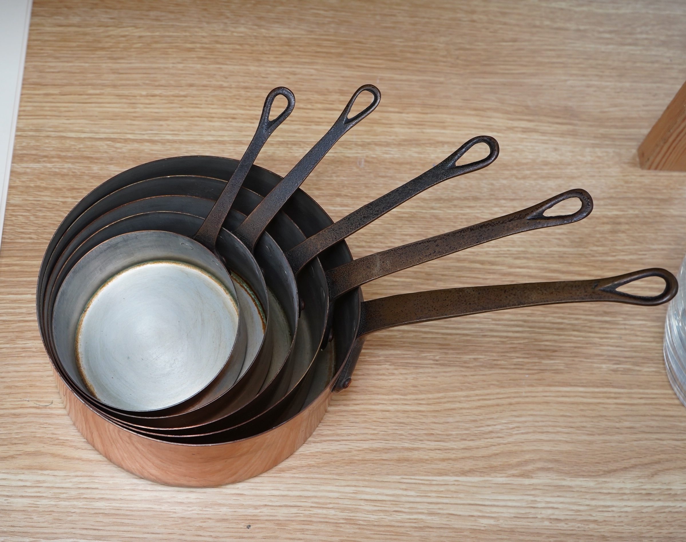 Les Metaux Ouvres. A graduated set of five copper pans. Condition - fair to good